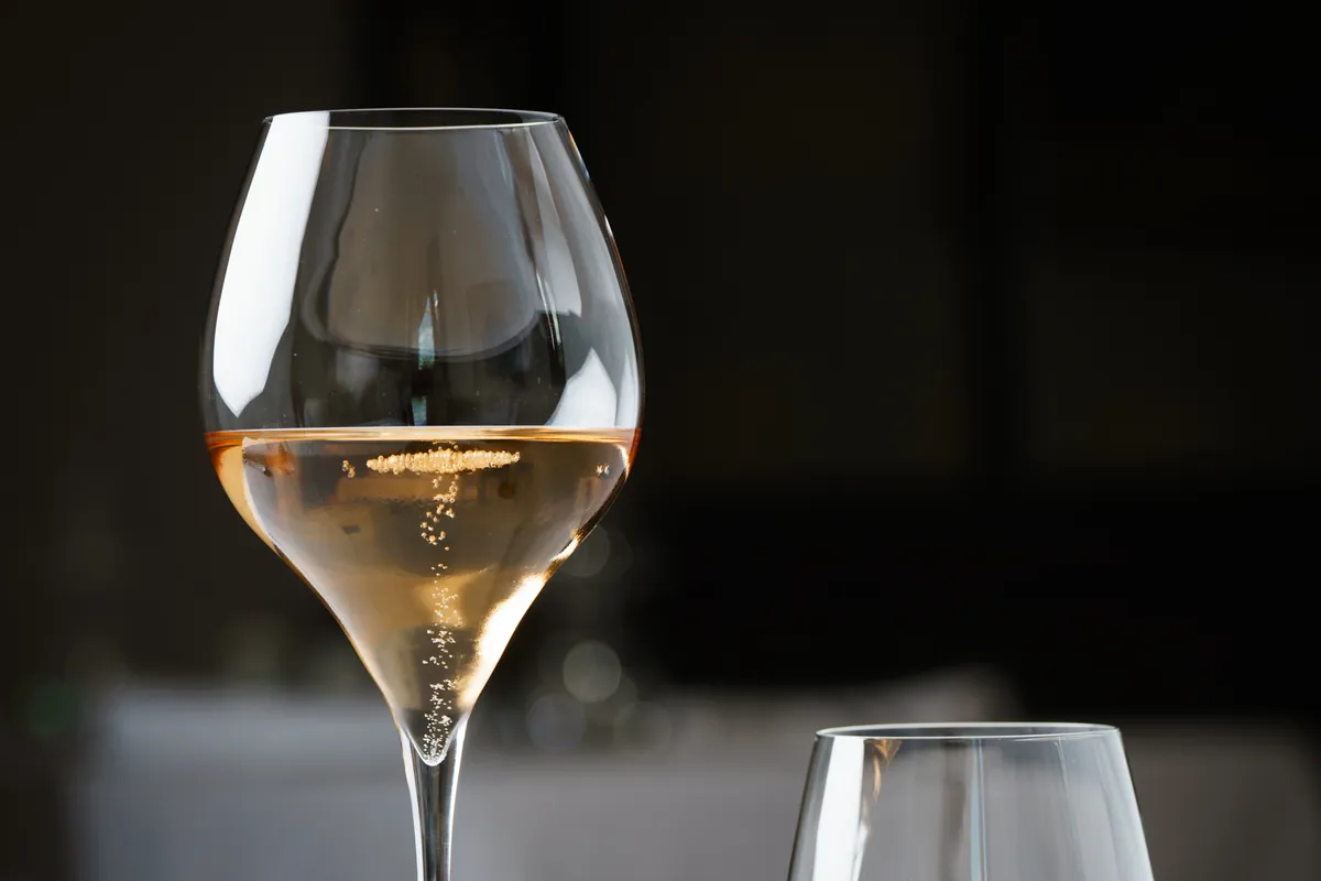 Un calice di vino bianco sul tavolo apparecchiato in sala